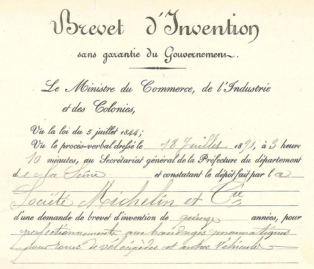 Photograph of the first patent filed by Michelin on July 18, 1891. The signatures are handwritten on this official document. It is written that Michelin has filed 'a fifteen-year patent application for improvements to pneumatic tires intended for the wheels of velocipedes and other vehicles'.