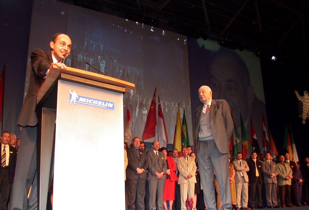 Photograph showing Édouard Michelin speaking, under his father's watchful eye.