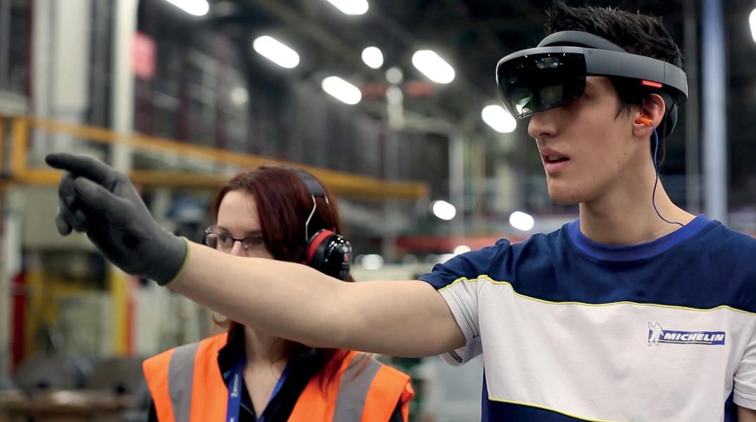 Photographie d'un employé Michelin portant un casque de réalité augmentée dans un atelier.