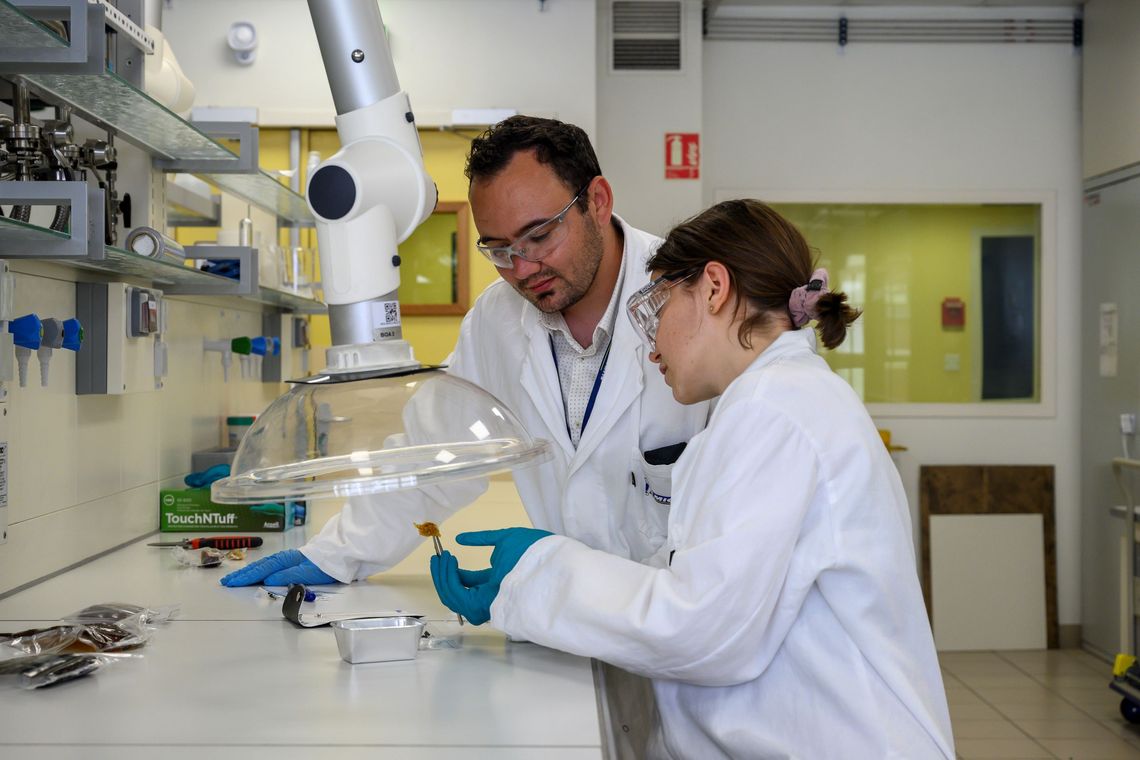 2 scientifiques, un homme et une femme, en blouse blanche, testent un échantillon de résine ResiCare dans un laboratoire.