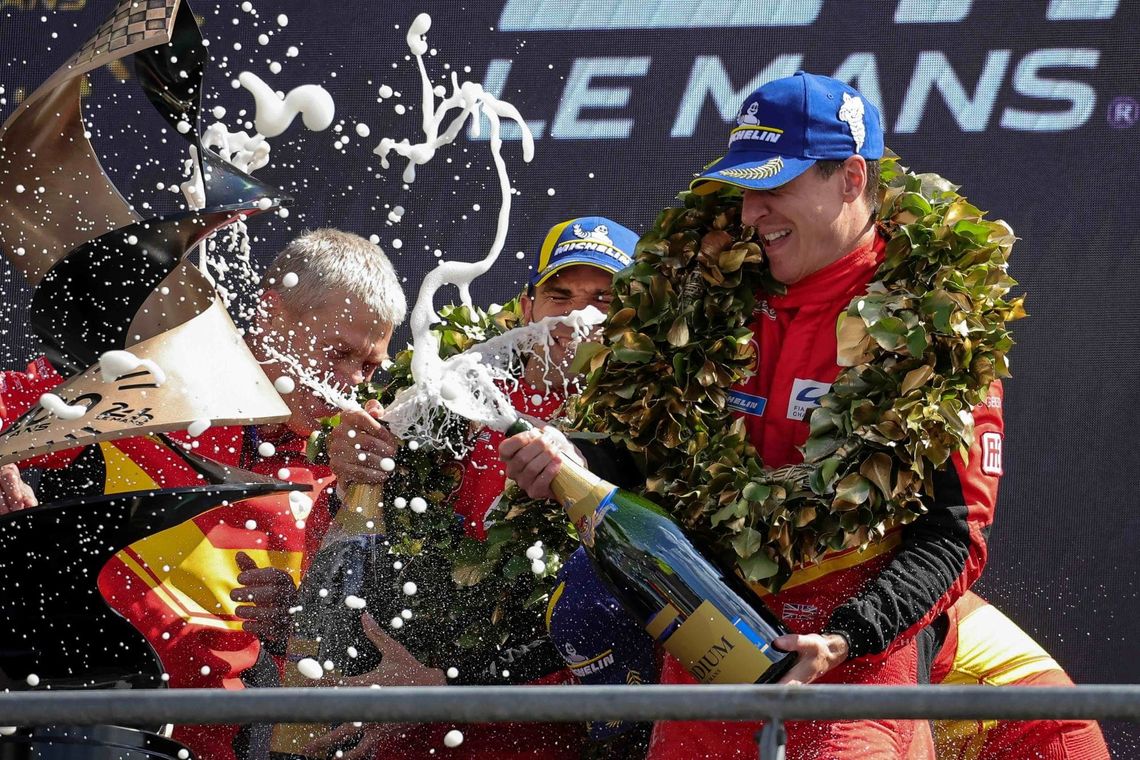 Le pilote CALADO James (Ferrari) célèbre sa victoire sur le Podium des 24 Heures du Mans 2023, en agitant une bouteille de champagne.