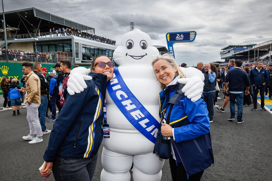 Deux femmes employées Michelin prennent la pose dans les bras de Bibendum